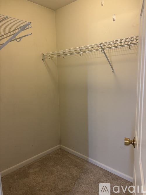 A small, empty room with a door and a couple of shelves.