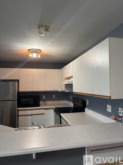 A kitchen with white cabinets and a black stove top.