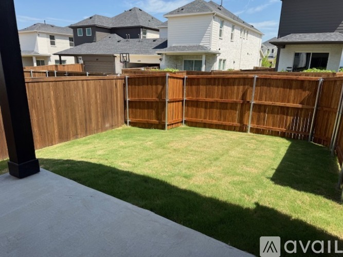 A backyard with a wooden fence and a grassy area.