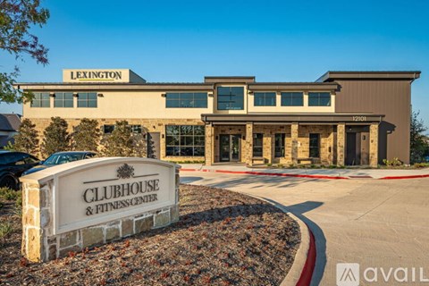 A building with a sign that says "Clubhouse & Fitness Center" in front of it.