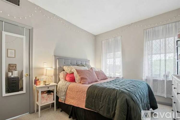 A bedroom with a bed, nightstand, and window.