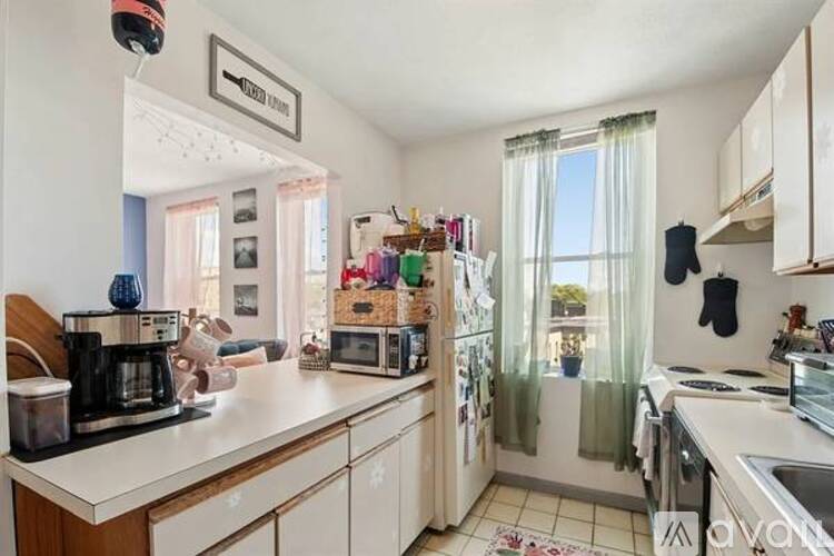 A kitchen with white cabinets and a wooden counter.