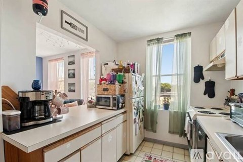 A kitchen with white cabinets and a wooden counter.