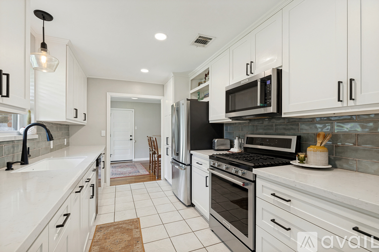 A kitchen with white cabinets and appliances.
