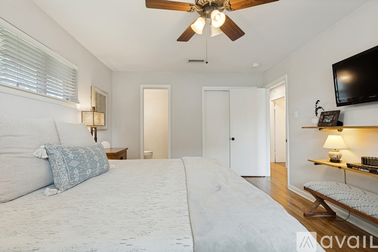 A bedroom with a large bed and a ceiling fan.