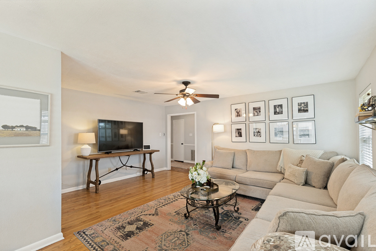 A living room with a couch, coffee table, and pictures on the wall.