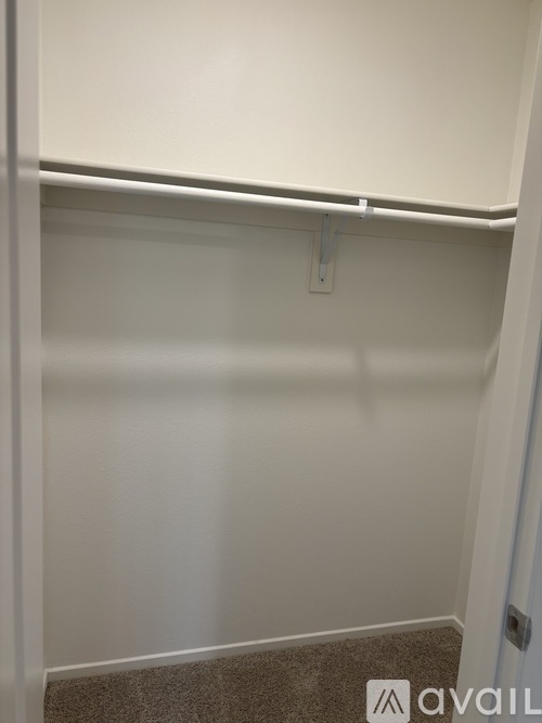 A white wall with a brown carpet.
