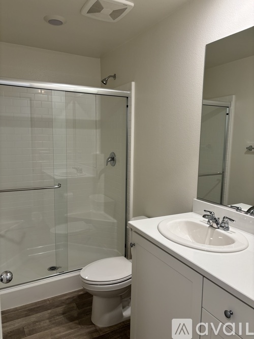 A white toilet sits next to a white sink in a bathroom.
