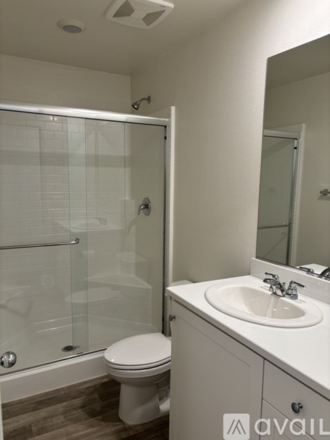 A white toilet sits next to a white sink in a bathroom.