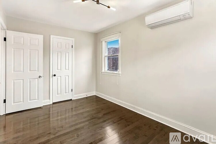 A room with two doors and a window with a view of a building.