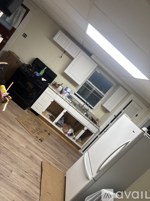 A kitchen with a black stove and white cabinets.