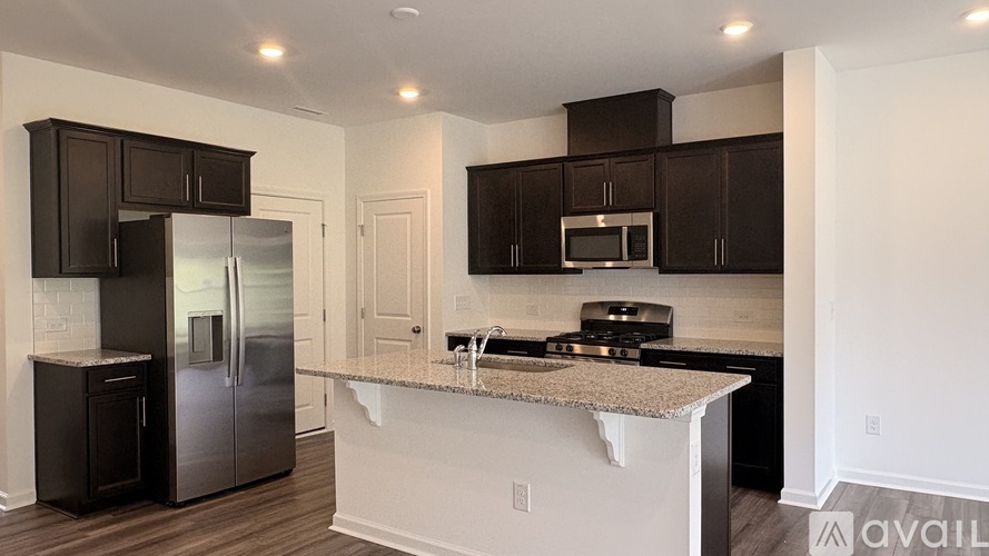 A kitchen with black cabinets and a granite countertop.