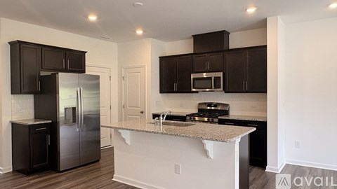 A kitchen with black cabinets and a granite countertop.