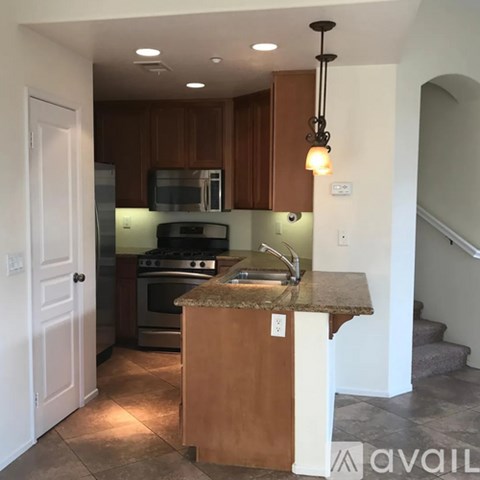 A kitchen with a granite countertop and stainless steel appliances.
