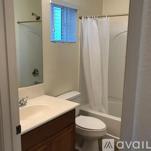 A bathroom with a toilet, sink, and shower.
