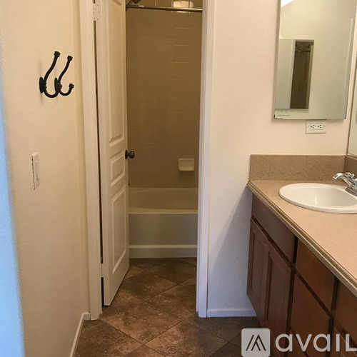 A bathroom with a sink, mirror, and towel rack.