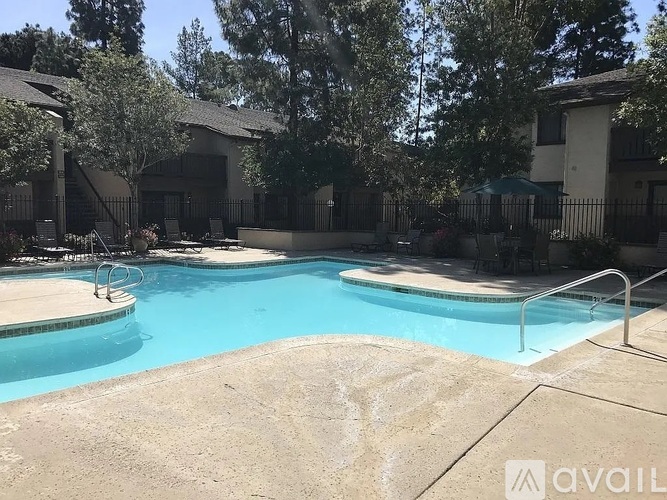 A pool surrounded by a fence and trees.