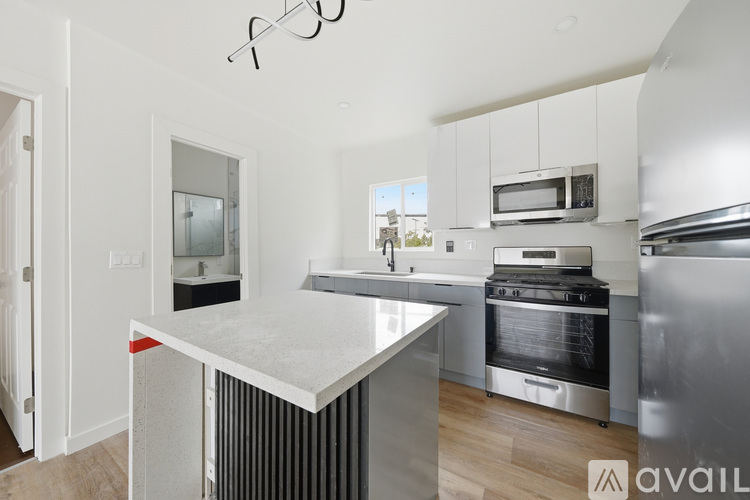 A modern kitchen with stainless steel appliances and white cabinetry.