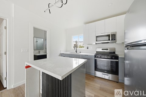 A modern kitchen with stainless steel appliances and white cabinetry.