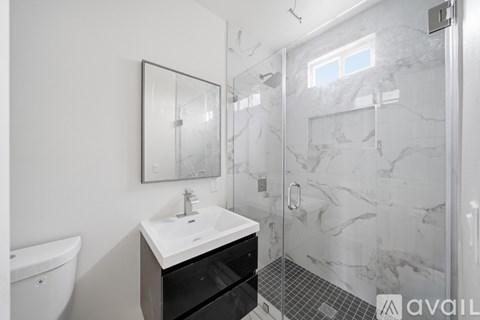 A bathroom with a sink, mirror, and shower.