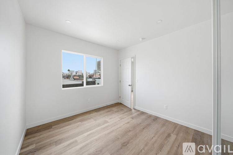 A room with a window showing a view of buildings outside.