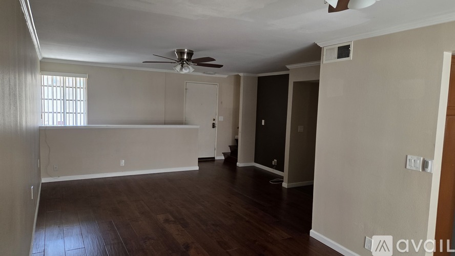 A room with a ceiling fan and a window with blinds.