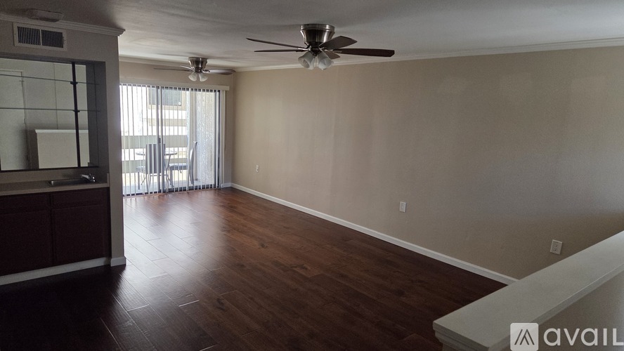 A room with wooden floors and a ceiling fan.