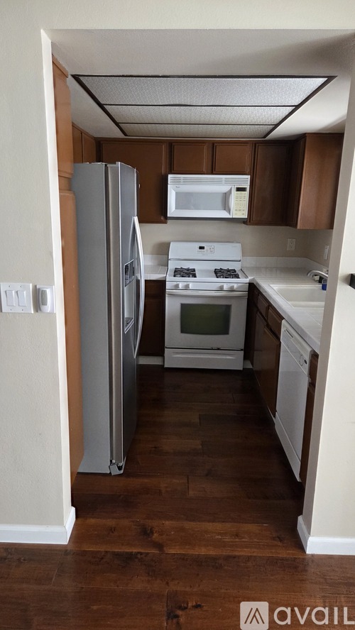 A kitchen with a refrigerator, oven, and microwave.
