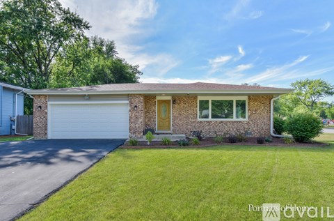 A house with a garage and a driveway in front of it.