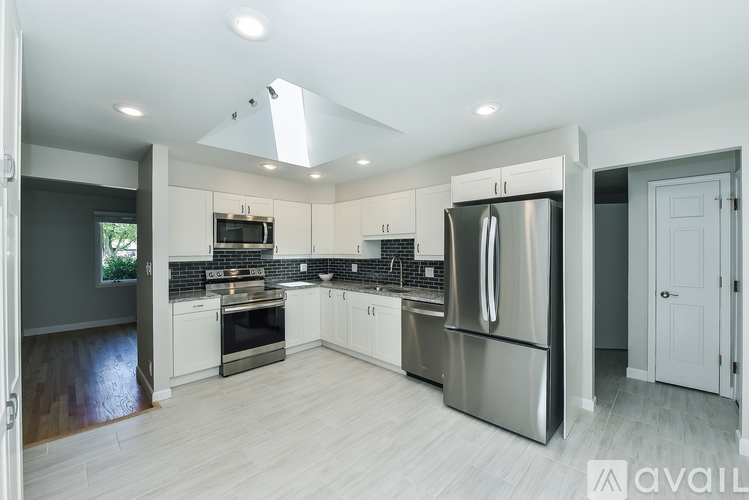 A modern kitchen with stainless steel appliances and white cabinets.