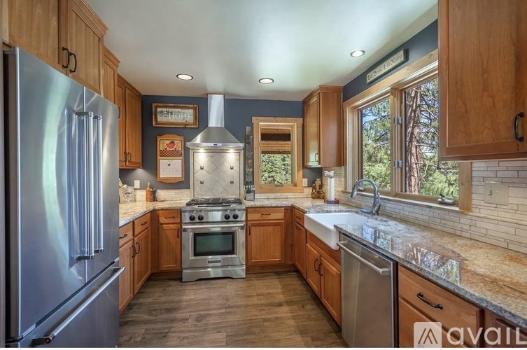 A kitchen with wooden cabinets and a stainless steel refrigerator.