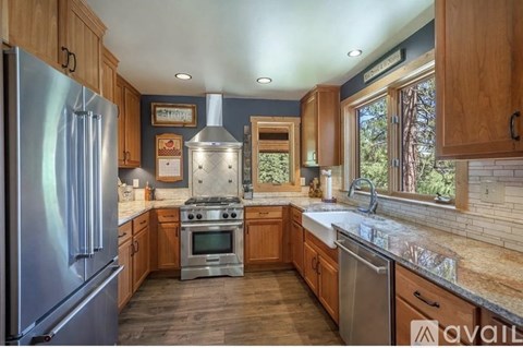 A kitchen with wooden cabinets and a stainless steel refrigerator.