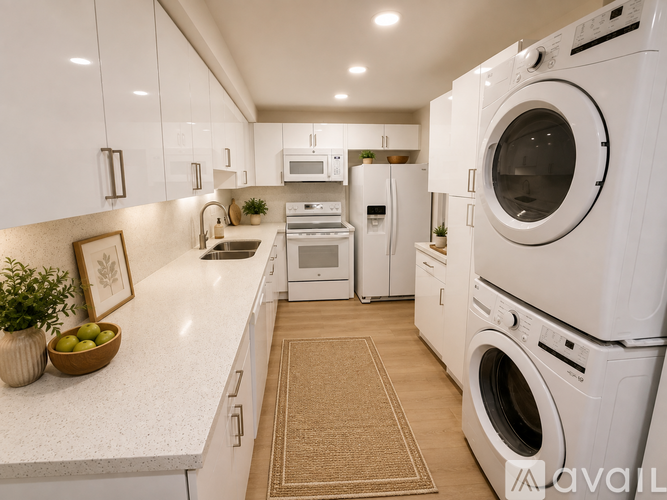 A modern kitchen with white appliances and a beige rug on the floor.
