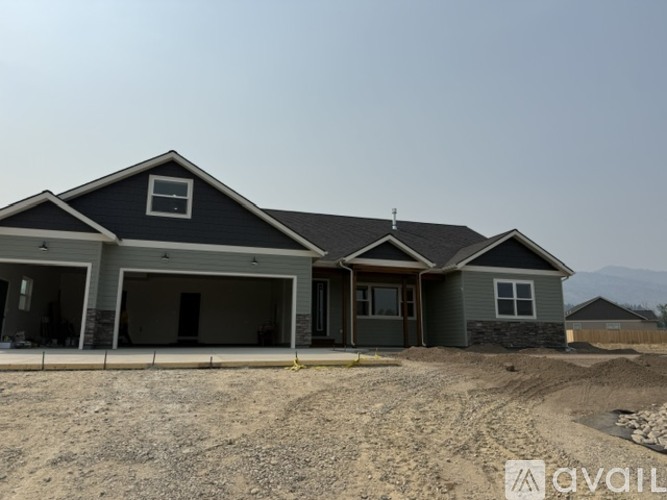 A house under construction with a grey roof and a sign that says "available".