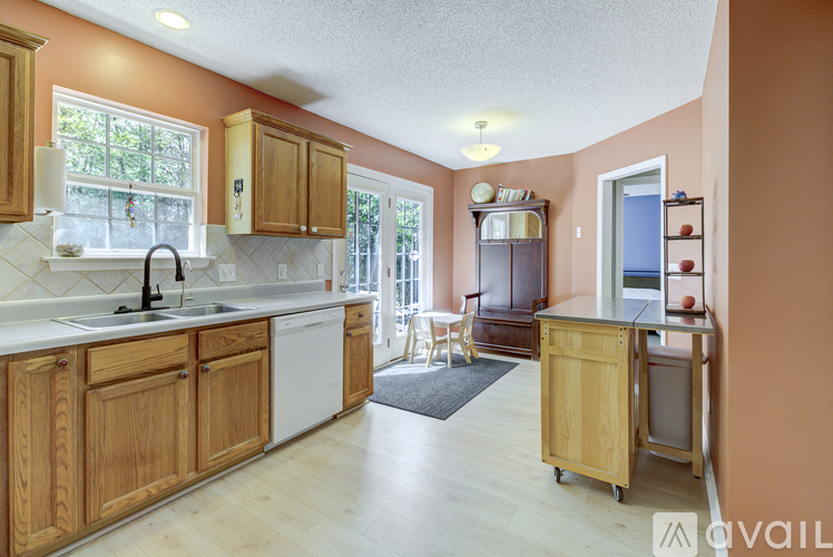 A kitchen with wooden cabinets and a white dishwasher.