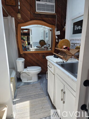 A small bathroom with a toilet, sink, and mirror.
