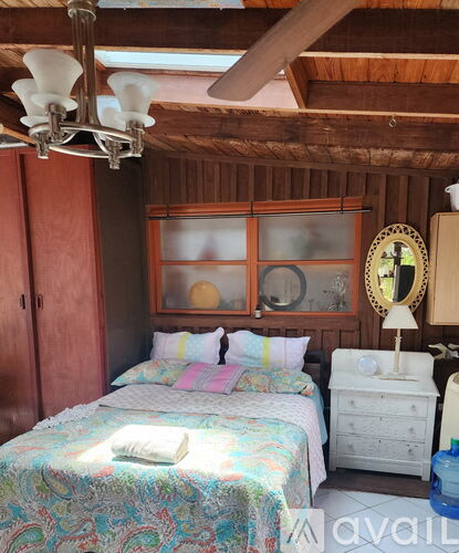 A bedroom with a bed, dresser, and mirror.