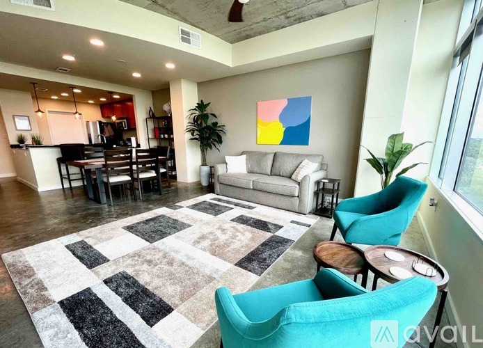 A living room with a rug, a couch, a table and chairs.
