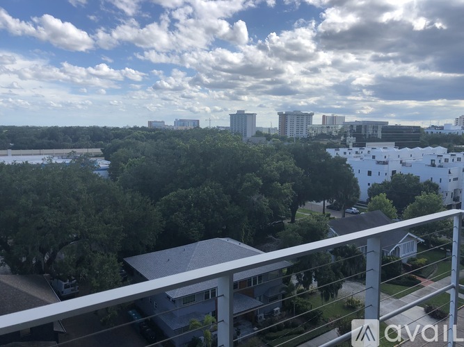A balcony overlooks a residential area with houses and trees.