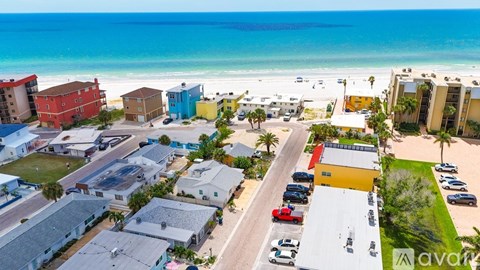 A beachfront community with colorful buildings and cars parked in the driveways.