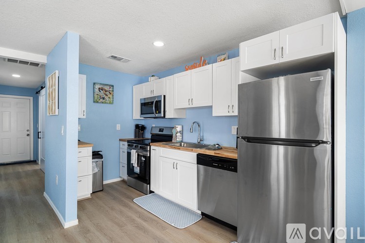 A kitchen with blue walls and white cabinets.