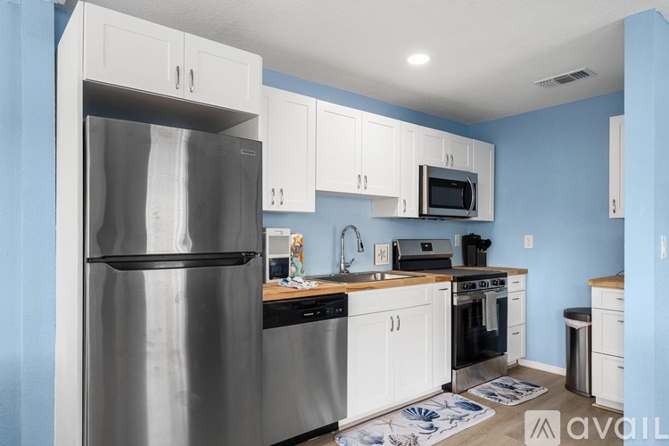 A kitchen with blue walls and white cabinets.