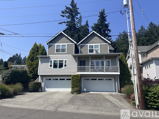 A two-story house with a garage is situated in a residential area.