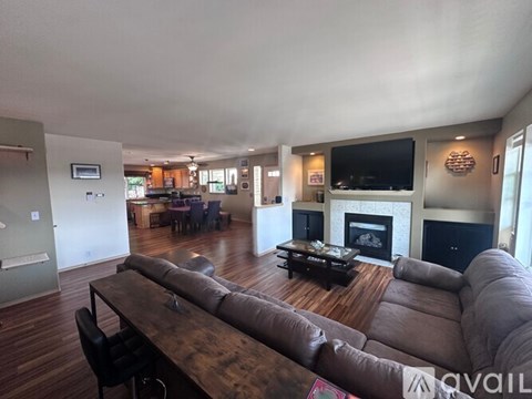 A living room with a brown leather couch and a wooden coffee table.