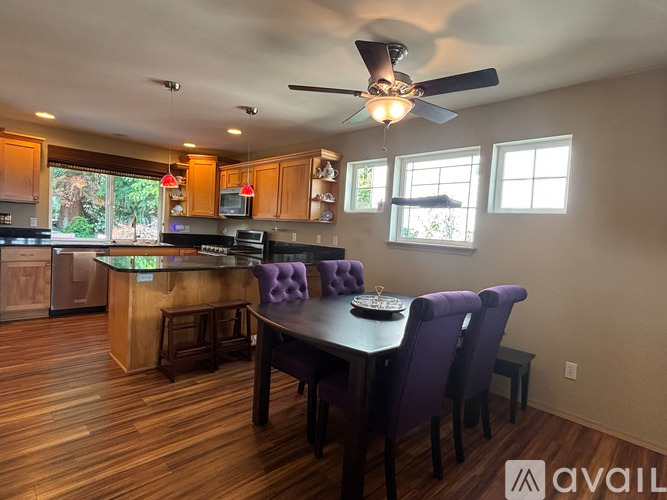 A kitchen with a dining table and chairs.
