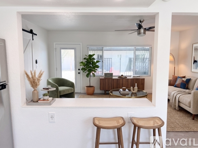 A living room with a sofa, a table, and two stools.