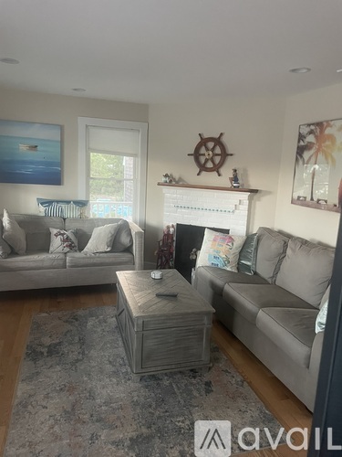 A living room with a grey couch, a coffee table, and a fireplace.