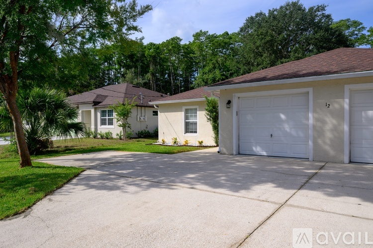 A house with a driveway and garage doors numbered 12.
