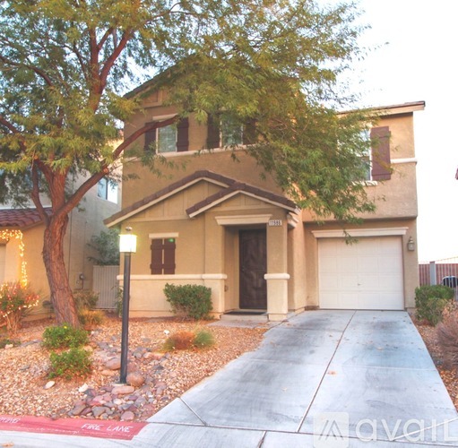 A house with a driveway and a tree in front of it.