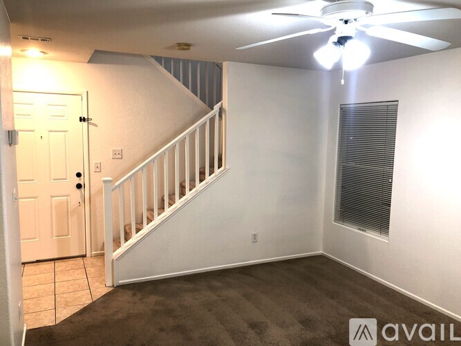 A room with a staircase and a ceiling fan.